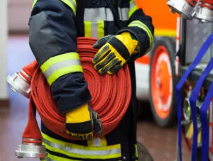 Firefighter carrying a rolled fire hose