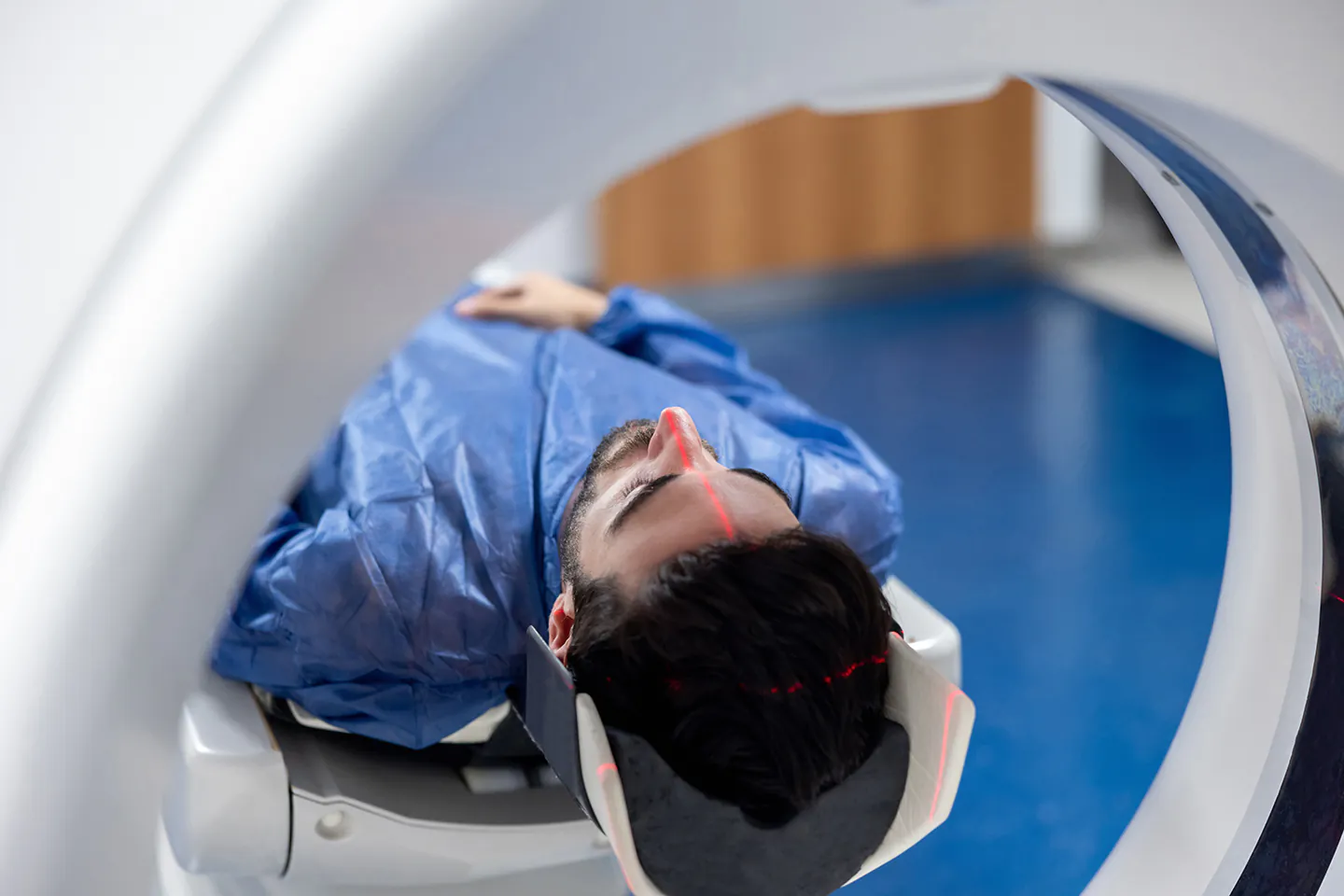 Woman in hospital gown with hands covering mouth shocked at what the doctor is showing her