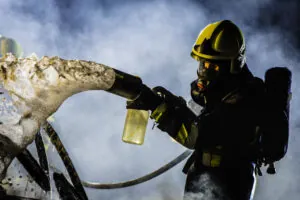 Firefighter extinguishes a blaze with foam